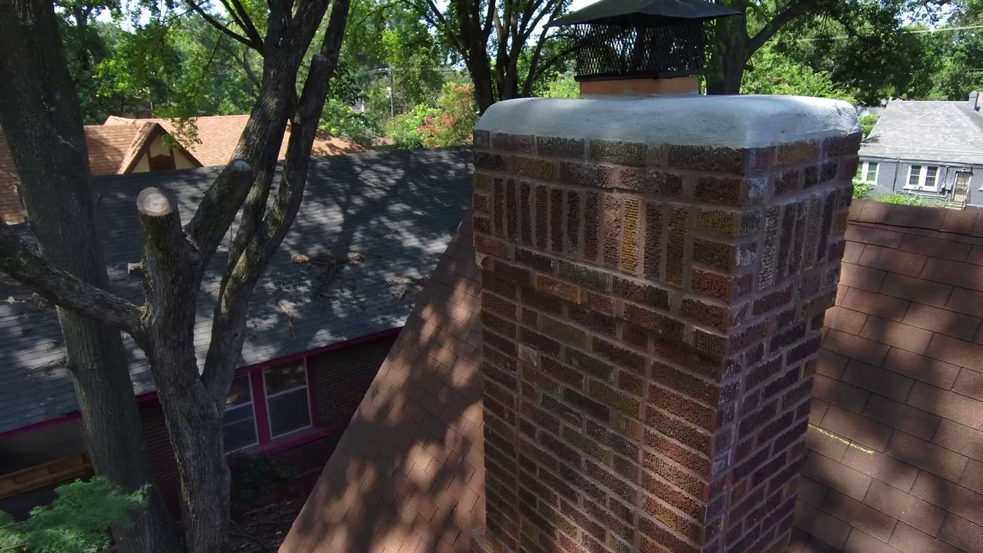 Close-up aerial drone photo of a rebuilt brick chimney with new crown and stainless cap, captured during a Madewell drone inspection in Memphis