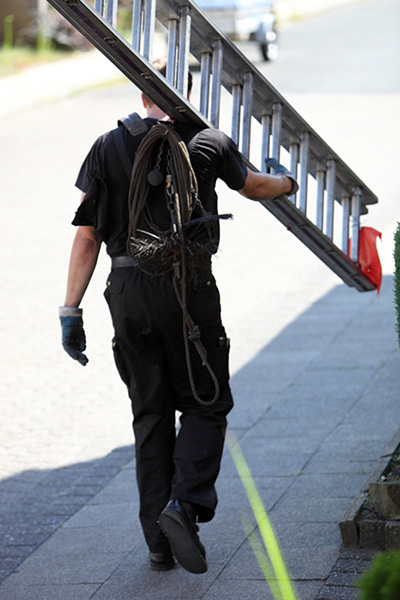 Chimney tech carrying ladder - Madewell Masonry