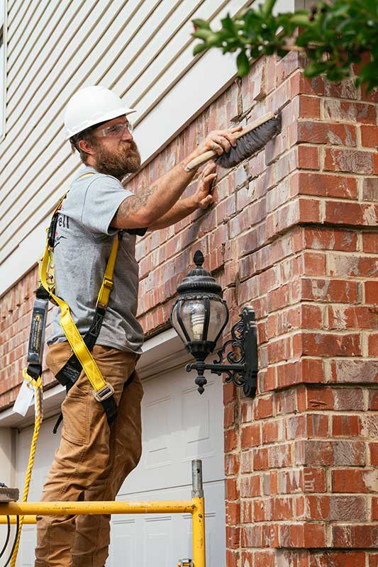 Technician smoothing out brick mortar